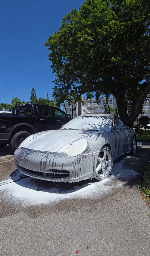 Porsche 911 covered in snow foam during a mobile wash